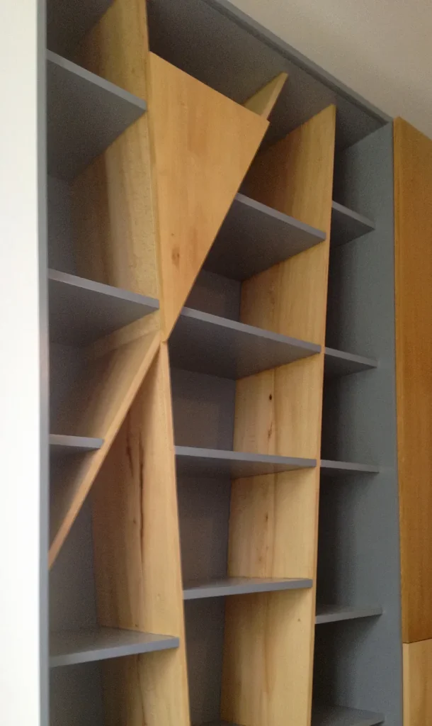 Bibliothèque sur mesure en bois et gris aux montants obliques