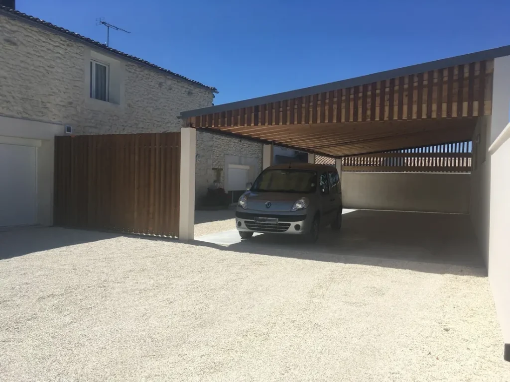 Carport en bois accolé à une maison en pierre