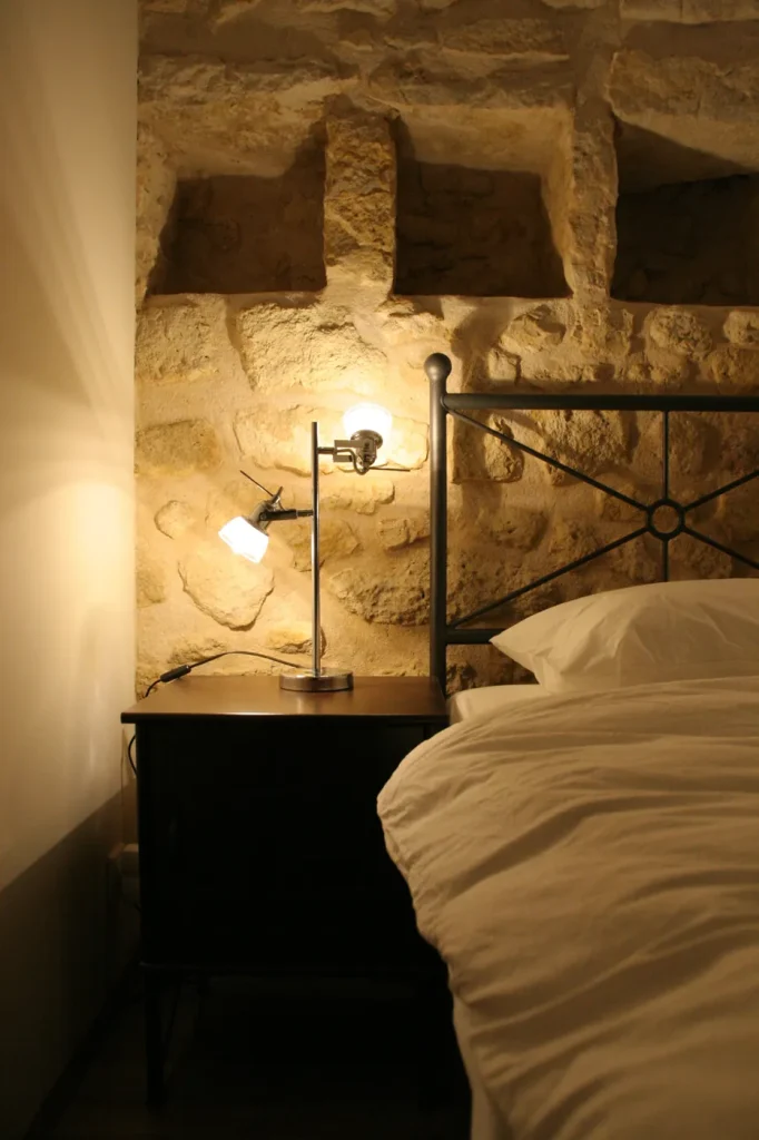 Chambre avec mur en pierre apparente et niches