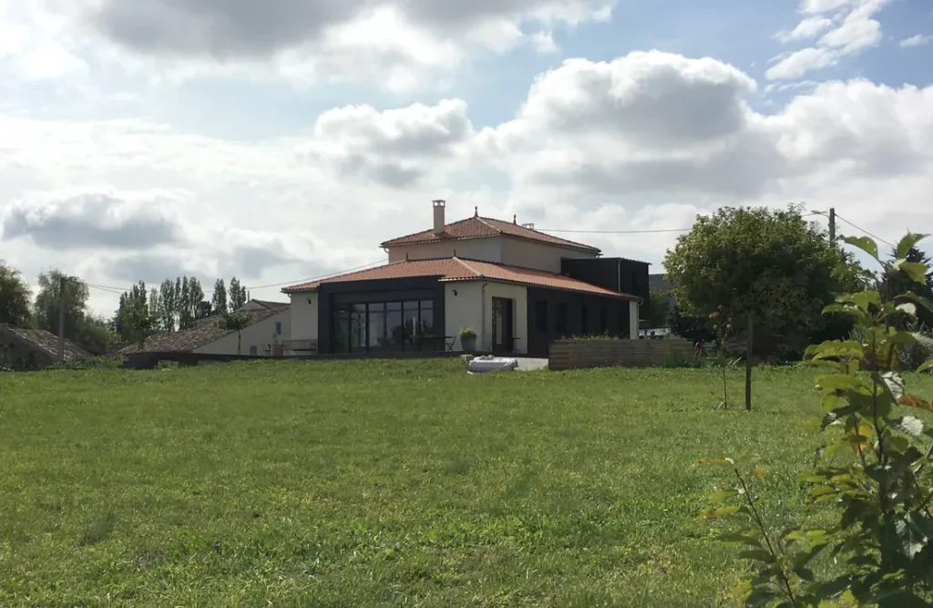 Maison et son extension au milieu d'une prairie